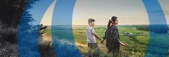 Couple viewing a green landscape from a hilltop